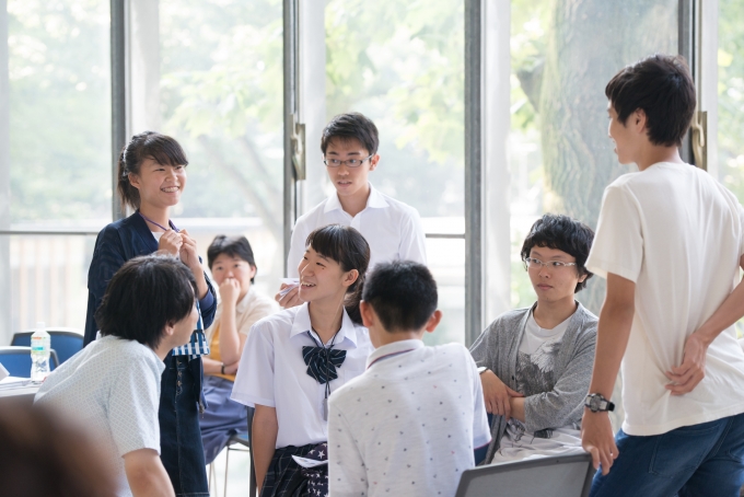 【写真】明るい日差しがさす中笑顔で語り合う学生。