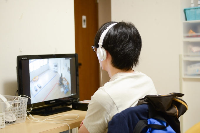 【写真】教室に来ていたお父さん。子供が遊んでいる姿をモニター画面で見ている。