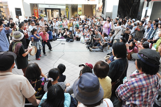 【写真】楽器を持ったりダンスのパフォーマンスをしている障害のある人たち。大勢の観客が楽しそうに周りを囲んでいる。