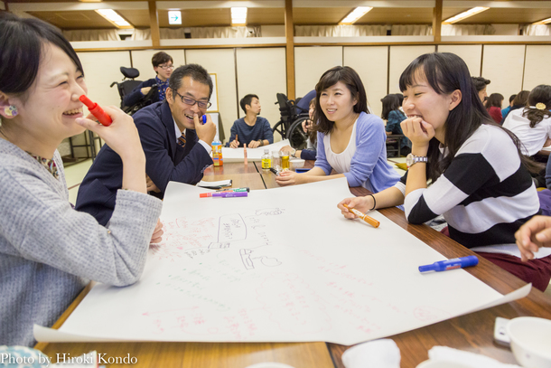【写真】少人数のグループで笑顔でアイデアを書き出す人たち