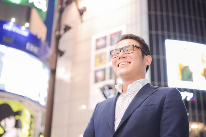 【写真】夜の都会で笑顔で立っているいとうじろうさん