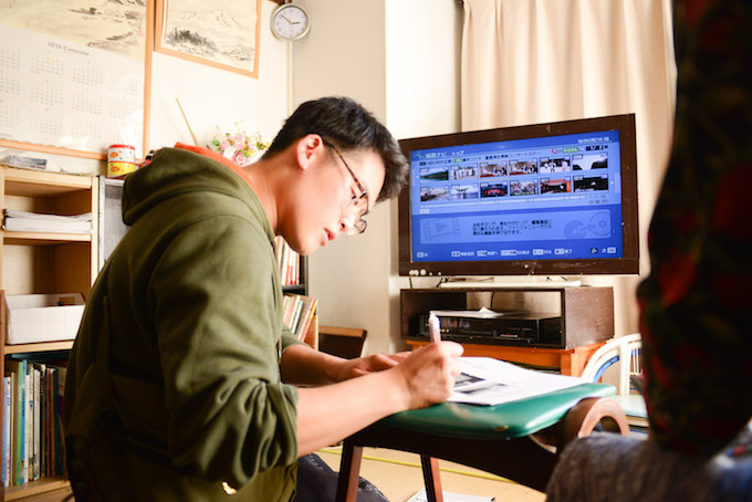 【写真】Sさん専用の説明書にさらに説明を書き込んでいるまつおかさん。
