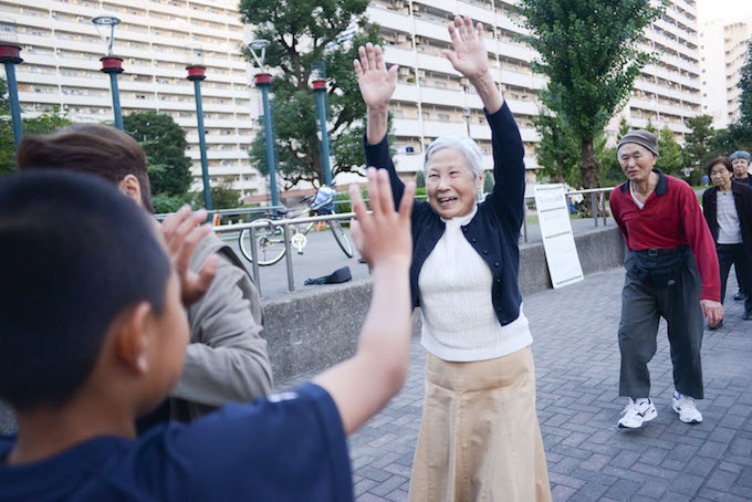 【写真】お互いにハイタッチするちぃちゃん体操の参加者たち。世代関係なく、楽しそうに交流している。