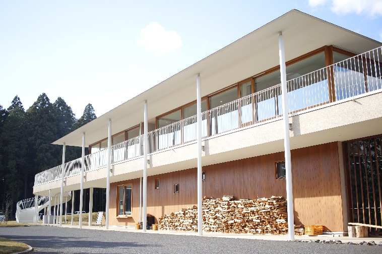 【写真】建築のこいするぶたけんきゅうじょの建物の前には、大量の薪が置かれている