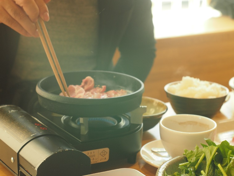 【写真】お客さんは一人一人席に運ばれるコンロの上で肉を温める。ご飯や飲み物もセットにできる