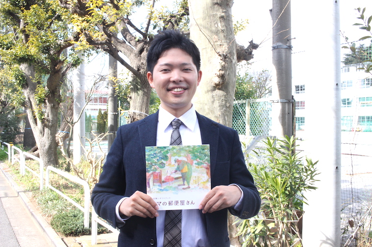 【写真】ギフトブックを手に微笑む、ちばなおきさん。