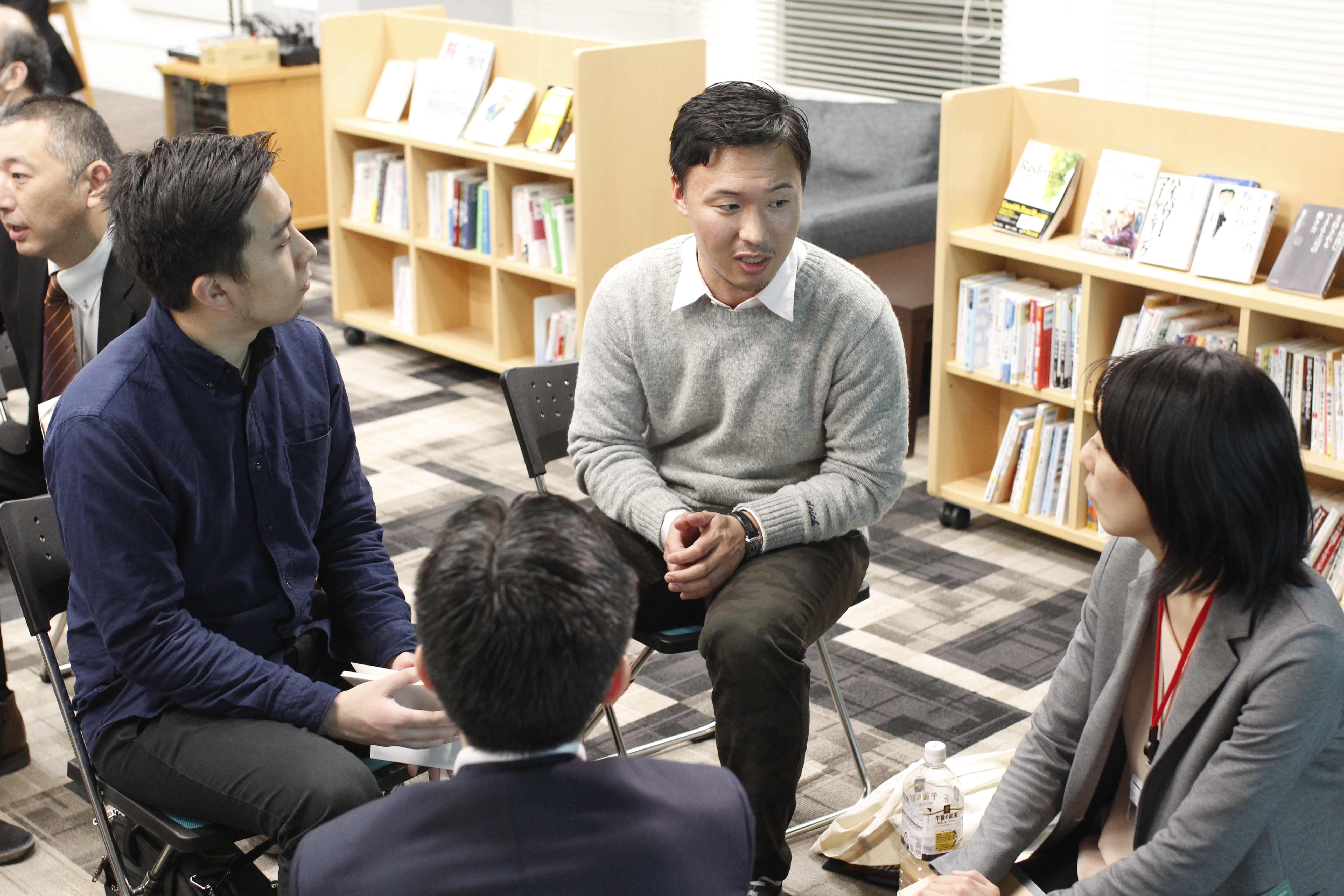 【写真】4人組になった参加者らが、真剣な表情で話している