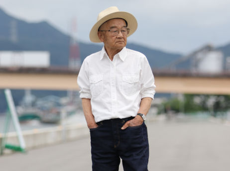 【写真】ジーンズパンツを履き、颯爽と歩く高齢者の男性。