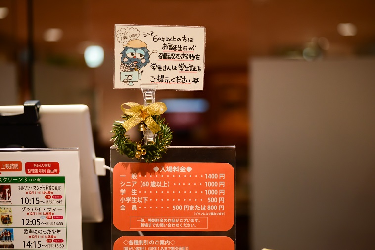 【写真】チケットカウンターに飾られている手書きのポップ。シニアと学生向けて年齢確認のお願いが書かれている。