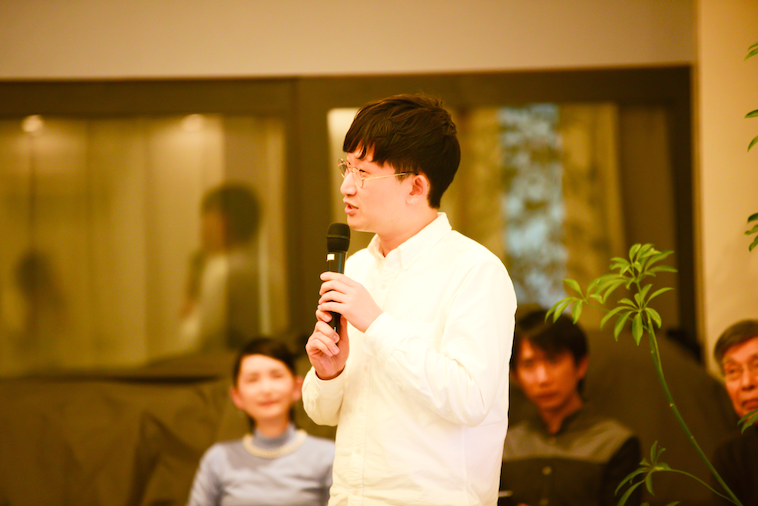 【写真】マイクを持ち、参加者に語りかけるおおたさん。他のゲストもおおたさんの話を聞いている