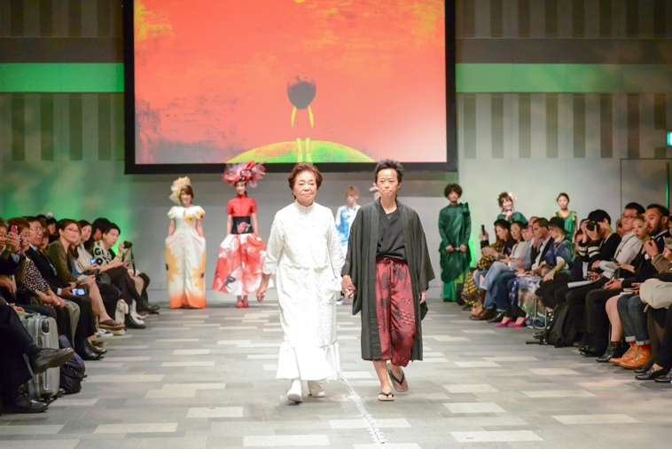 【写真】手を繋いでランウェイを歩くまきさんとそうまさん