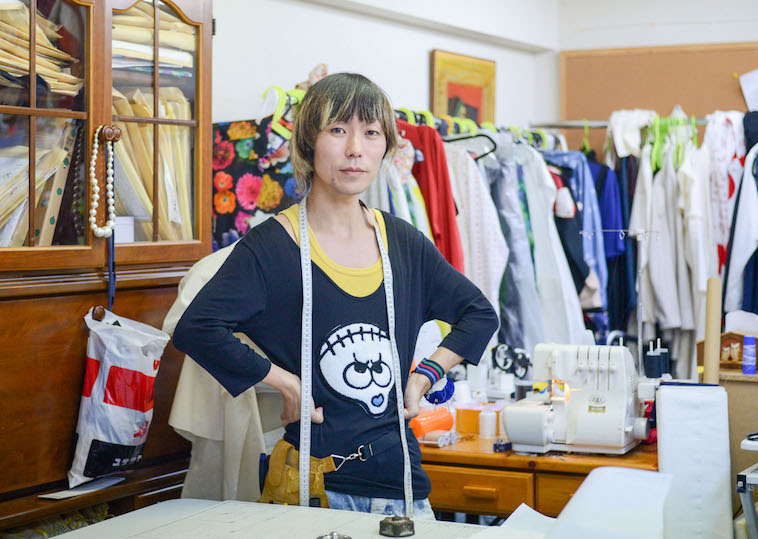 【写真】様々な服屋ミシンがあるtenboの作業所で立っているつるたたかふみさん