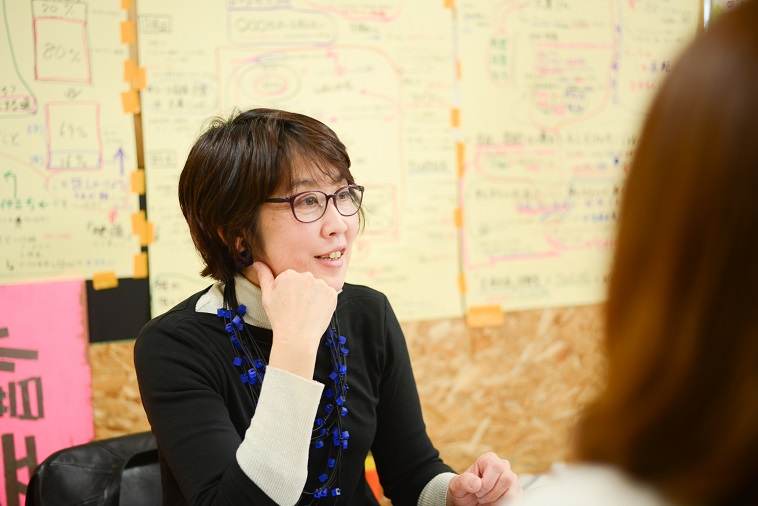 【写真】インタビューに応えるくぼたさん。話しながら笑みを浮かべている。