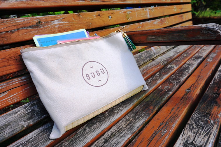 【写真】木製のベンチに置かれたスースーのクラッチバッグ。自然の空気とも相性が良いようだ。