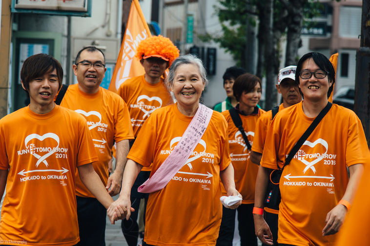 【写真】揃いのTシャツをきて歩く7人の大人たち。穏やかな空気が伝わる。