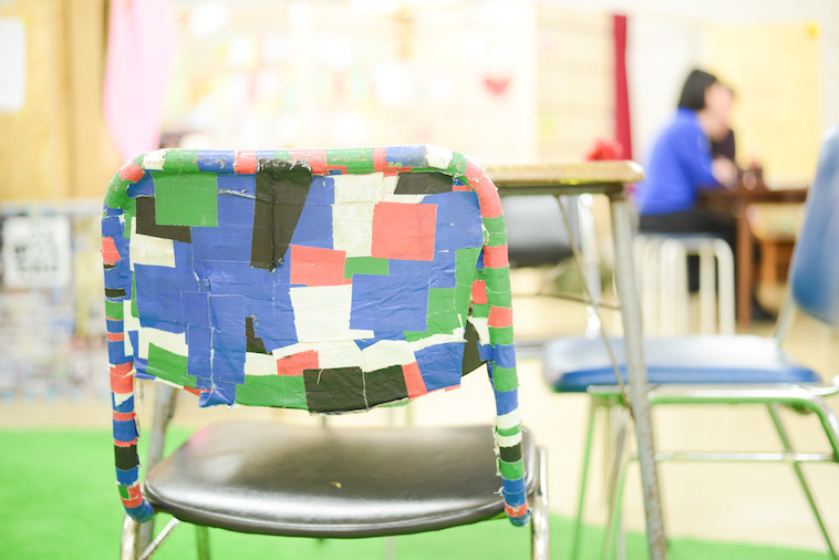 【写真】あるすのゔぁにあるパイプ椅子。黒や緑ピンク、青のテープが貼られている。