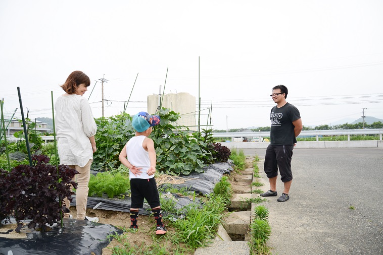 【写真】畑で楽しそうに話すたはらまさのりさんと子どもと子どもの村福岡のスタッフ