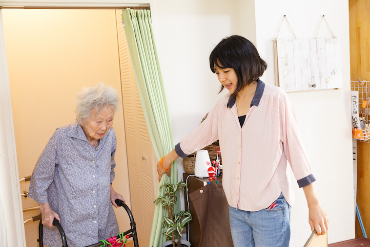 【写真】前に進もうとするおばあさんのために、カーテンを開けて進行をフォローするたかすさん