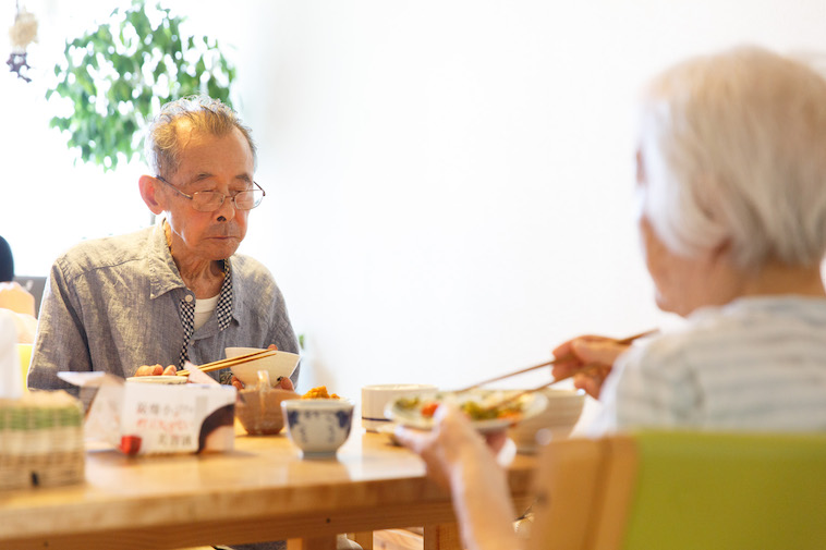 【写真】黙々とテーブルに並んだ食事をとるおじいさんとおばあさん