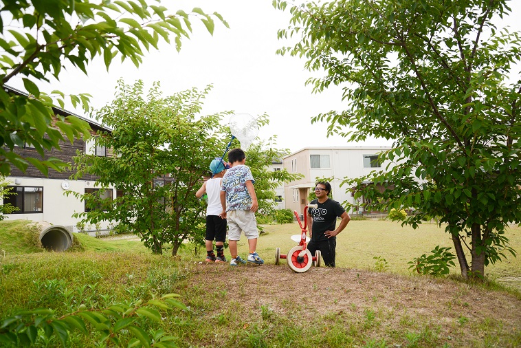 【写真】外に出て遊んでいるたはらまさのりさんと子どもたち。子どもは虫取り網を持っていて楽しそうだ