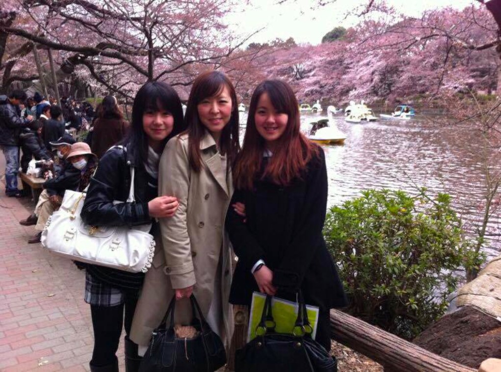 【写真】笑顔の二人の娘さんとくらさわなつこさん。桜の花びらが川面に浮いている