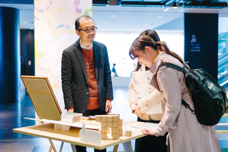 【写真】店頭でプロダクトを説明するスタッフに、耳を傾けるお客さん。穏やかな空気が流れている。