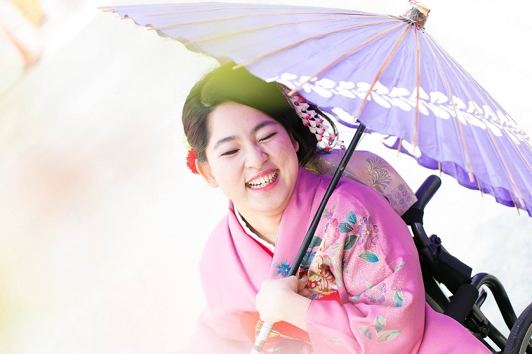 【写真】車椅子用の振袖を身につけ、満面の笑みで写る女性。