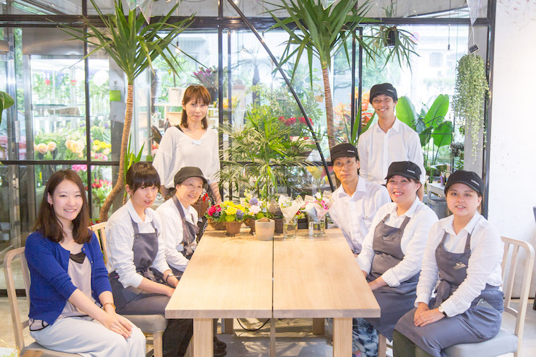 【写真】働くスタッフ8人が並んでこちらを見て微笑んでいる