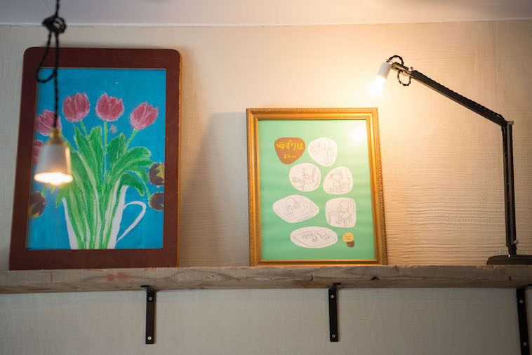 【写真】額縁に入れられた絵を暖かい光が照らしている