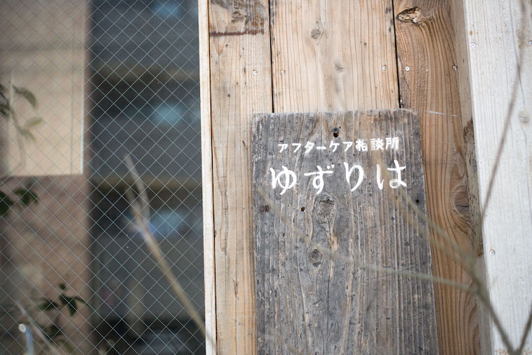【写真】木製の看板には「アフターケア相談所ゆずりは」と書かれている