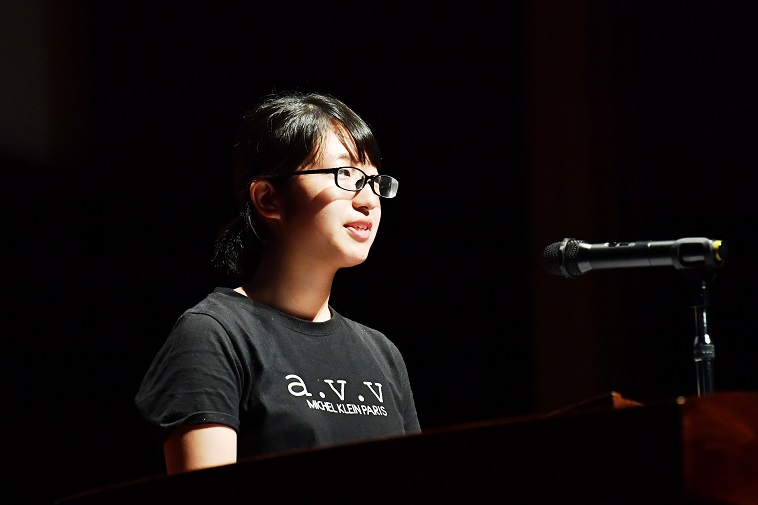 【写真】マイクの前で、明るい表情でスピーチをする女の子