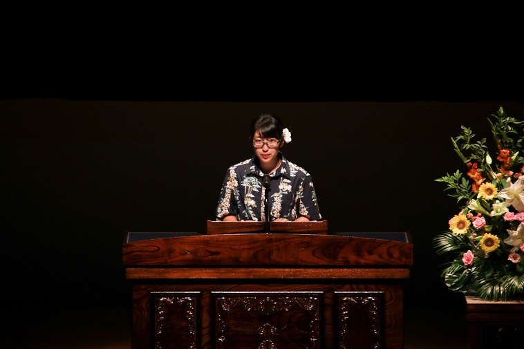 【写真】緊張した面持ちで、壇上に上がるごんちゃん。ブラウスと花飾りがとても似合っている