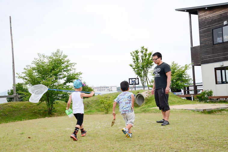 【写真】子どもの村福岡のたはらまさのりさんと虫取り網やスコップを持った子どもたち