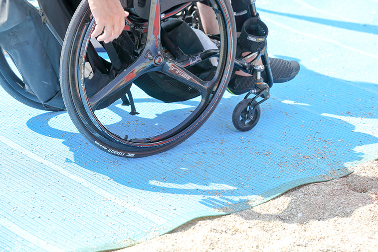【写真】ビーチマットを敷いて車椅子を走らせた時の様子。タイヤが一切めり込んでいない
