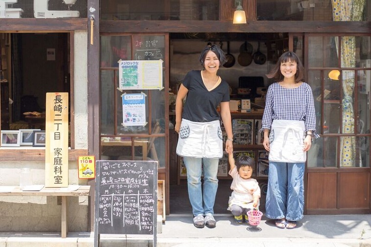 【写真】ながさきにちょうめかていかしつの前にたつふじおかさんとふかのさんとかなめちゃん