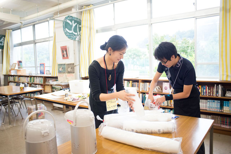 【写真】プラスチックコップを空けてカフェの準備をしているスタッフたち