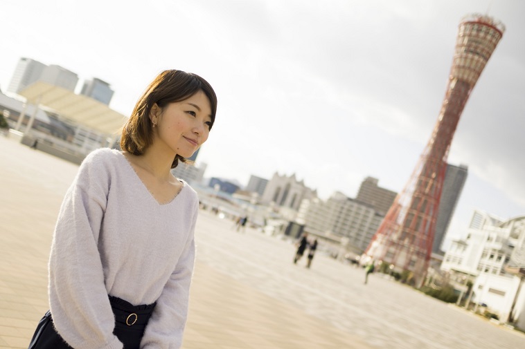 【写真】神戸のポートタワーを背景に、微笑むゆうかさん