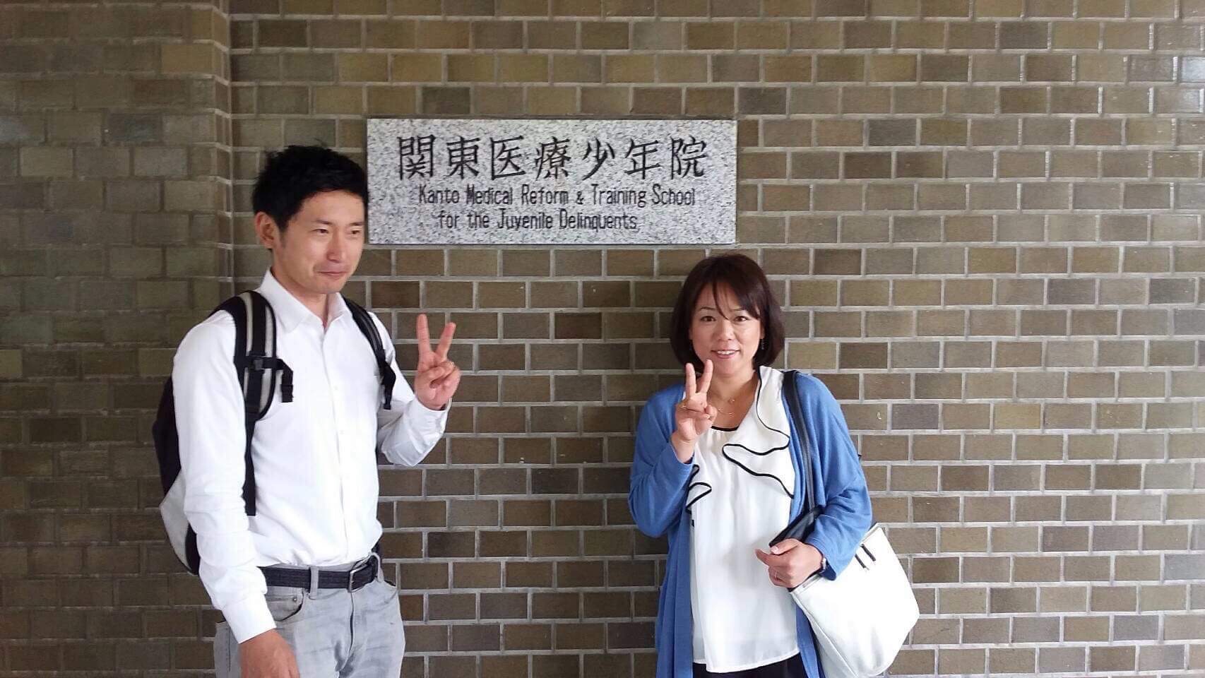 【写真】関東医療少年院の建物前で微笑むつとみひろしさん、なかむらすえこさん
