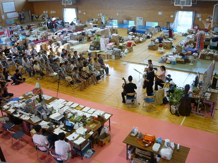 【写真】被災地の体育館でワークショップを行う日本フィルのメンバーと聞き入る被災者