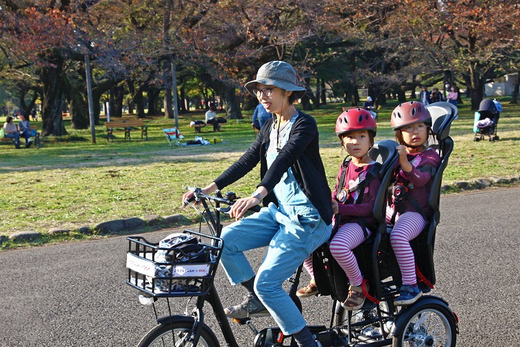 【写真】ふたごじてんしゃに二人の子供を乗せて体験するお母さん