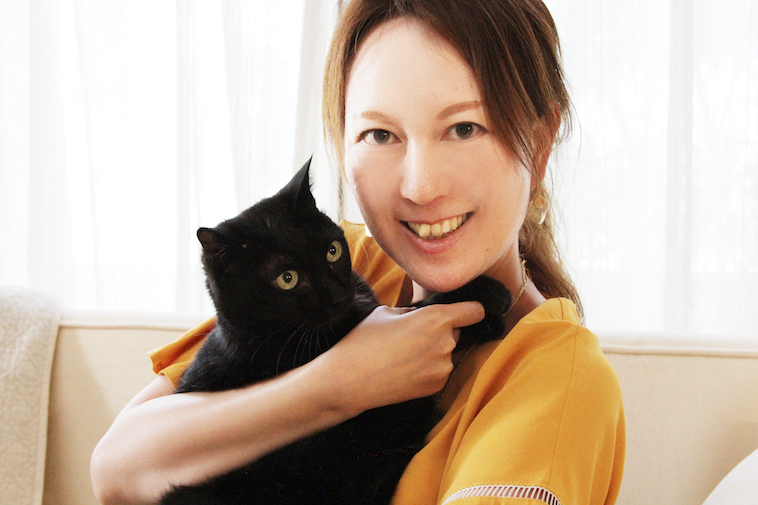 【写真】黒猫を抱いて微笑むセリさん