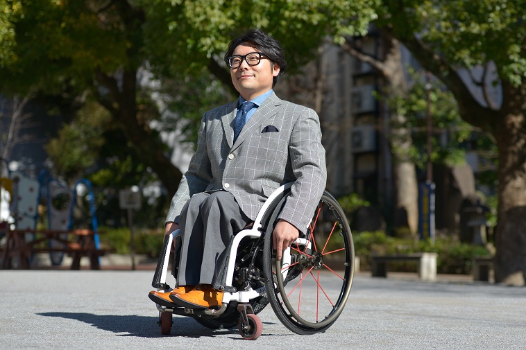 【写真】スーツを着て車椅子に乗る男性