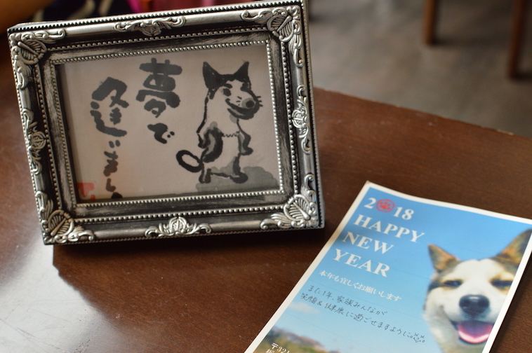  【写真】しみずさんがあくつさんの為に書き綴った書。あくつさんの愛犬さくらのイラストと、「夢であいましょう」という言葉がつづられている。