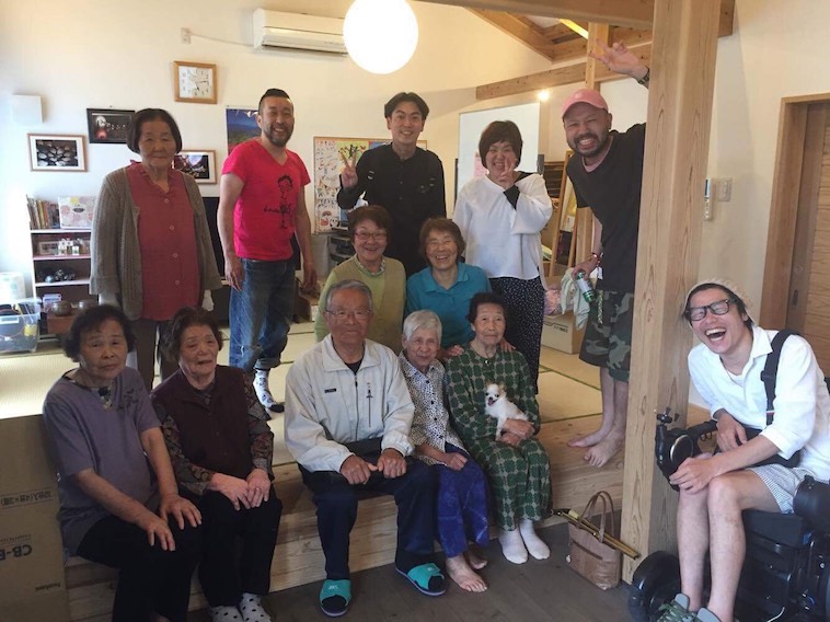 【写真】笑顔のおちあいさんと、熊本で出会った方々の写真。みなさん笑顔でほほえんでいて和やかな雰囲気が流れている。