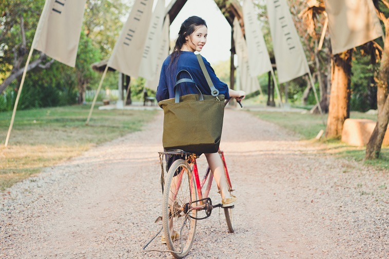 【写真】SALASUSUのカバンを斜めがけして自転車にまたがる女性