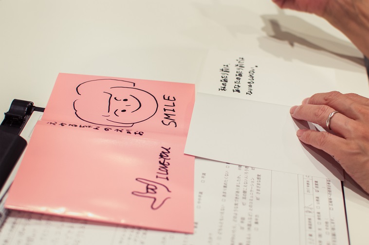 【写真】参加者が書いた本のカバーの写真。えみるちゃんの笑顔と書き、えみるちゃんのイラストとスマイルという文字は大きく描かれていた。