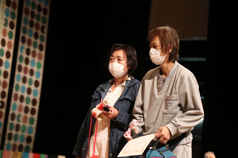 【写真】タカトリヨシアキさんとナカニシアツコさん。二人ともマスクをし、浮かない表情をしている