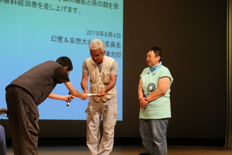 【写真】ナガオトシユキさん、カヨコが賞状を受け取っている