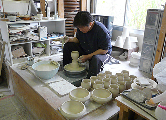 【写真】工房で陶器をつくるおおさわかずよしさん