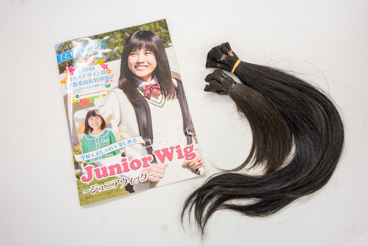 【写真】子ども向けウィッグのパンフレットと、ドネーションされた髪の毛の束